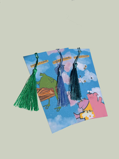 Three tassel bookmarks on a 'Frog and Friends' themed card with cartoon characters.