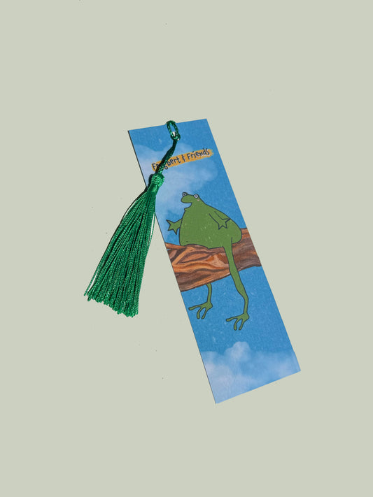 Bookmark with a green frog illustration and tassel on a light gray background